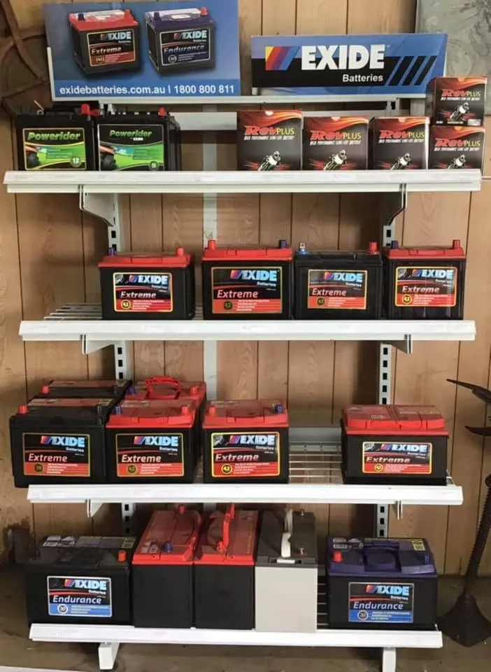 A shop shelf of Exide batteries under Exide signage