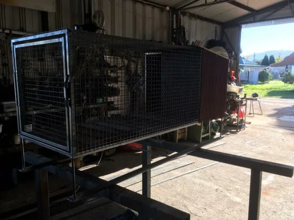 A custom mesh dog cage on a steel frame, built in the workshop