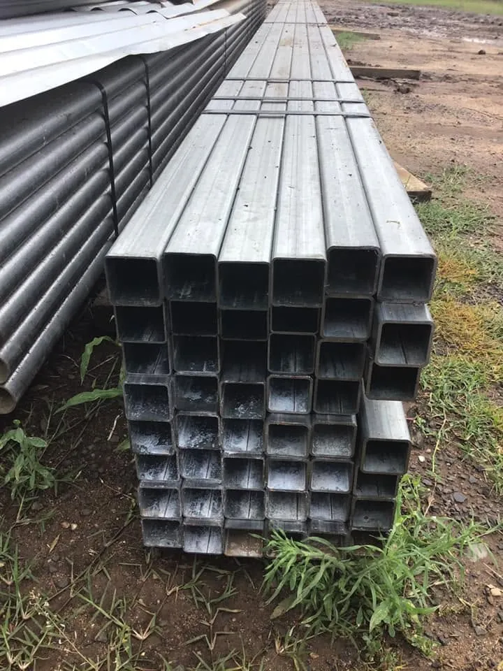 A long stack of galvanised square hollow section in the yard, seen end-on